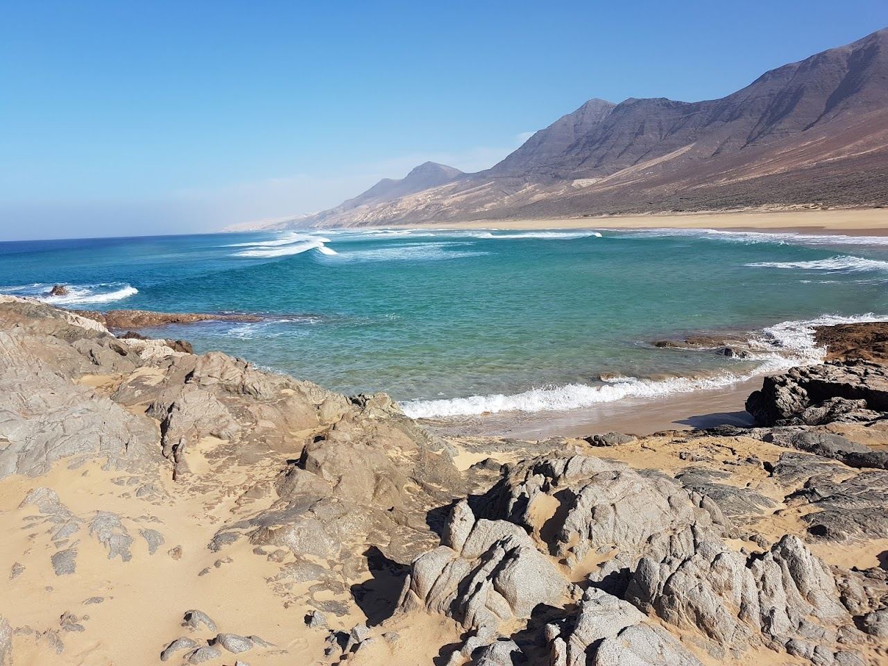 Vast wild golden beach under dark mountains at Cofete in Fuerteventura