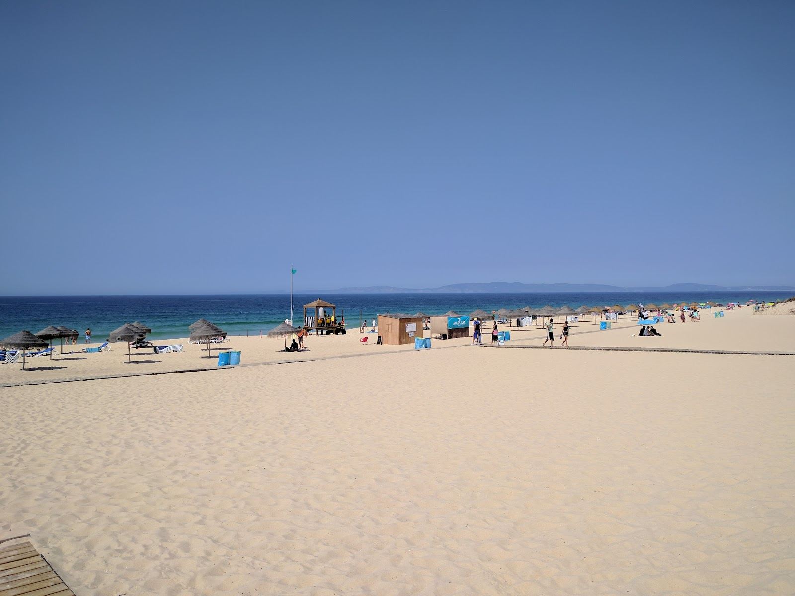 The wide soft sand and open Atlantic surf of a Comporta beach behind the dunes in Portugal