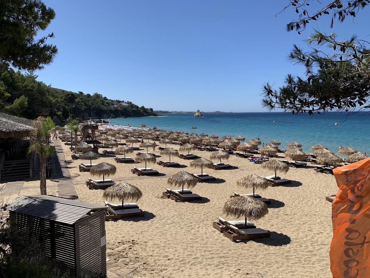 Sunbeds and umbrellas of Costa Costa beach bar on the golden sand of Makris Gialos at Lassi, Kefalonia