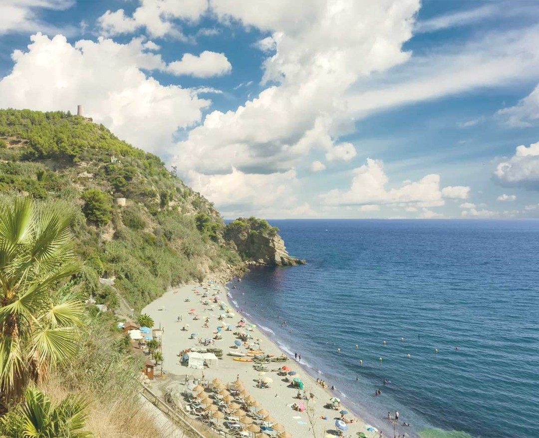 Quiet sandy cove backed by cliffs and greenery near Maro on the eastern Costa del Sol