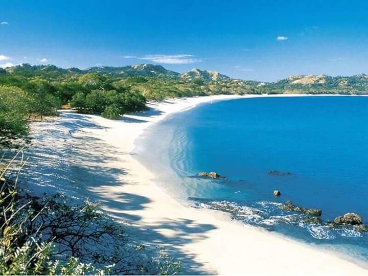 The pale crushed shell sand and turquoise water of Playa Conchal in Guanacaste