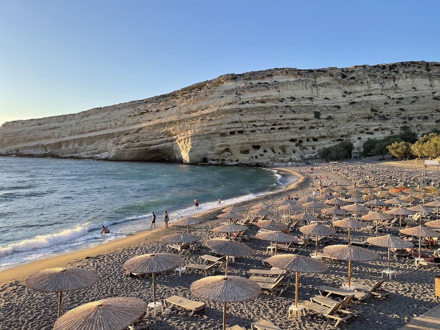 Sandy cove and cave cliffs at Matala beach on the south coast of Crete