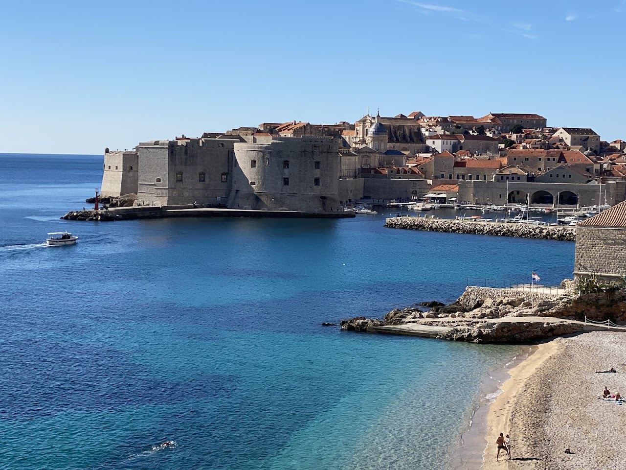 Pebble beach at Banje with the walls of Dubrovnik old town behind