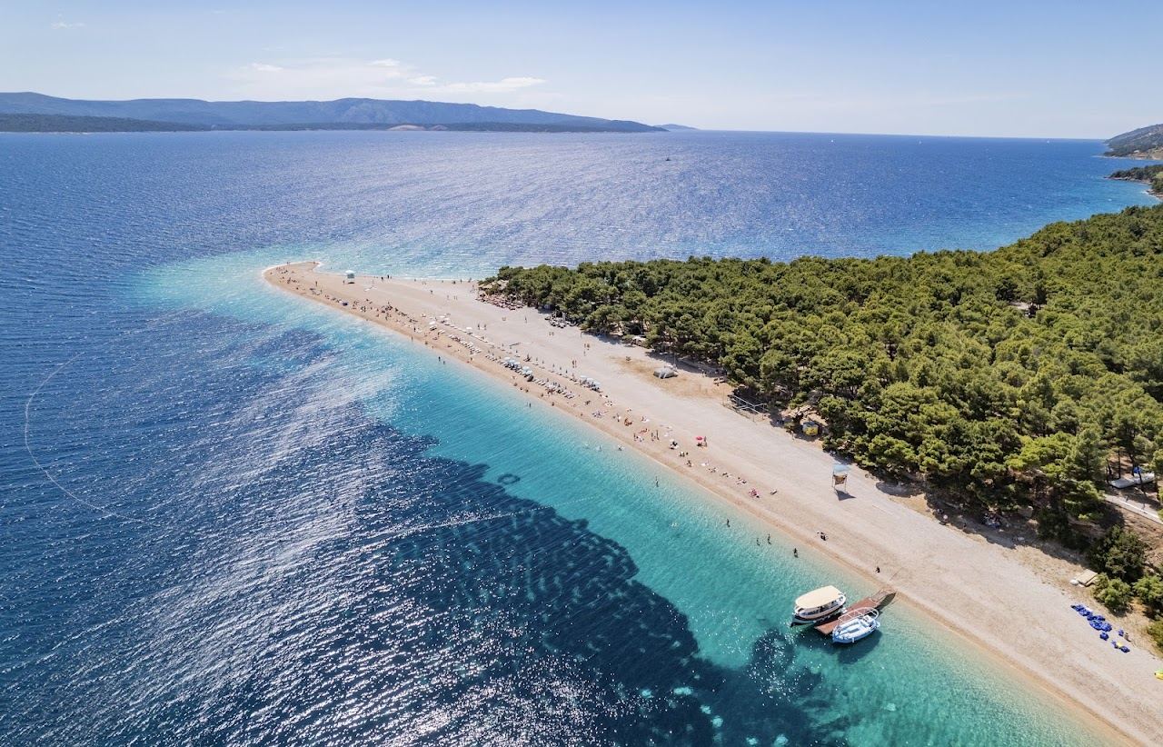 The golden spit of Zlatni Rat reaching into clear water off Brac in Croatia