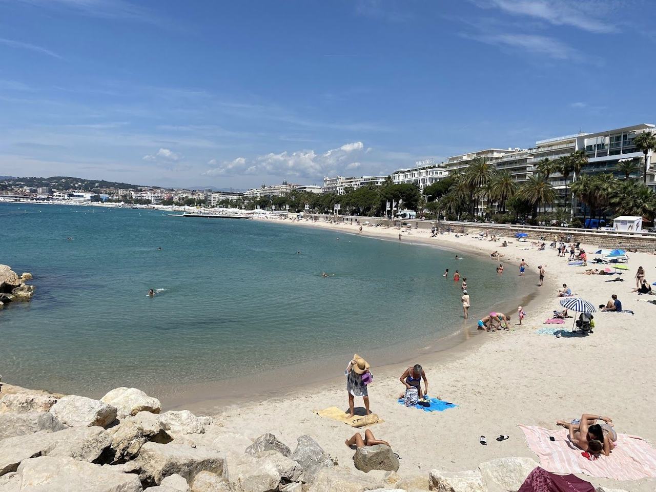 Beach loungers and clear sea along La Croisette below the grand hotels of Cannes France