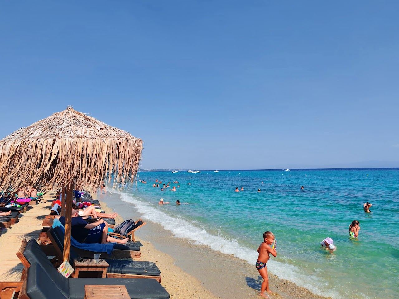 Long pale sand and shallow clear water along Polichrono beach on the Toroneos Gulf