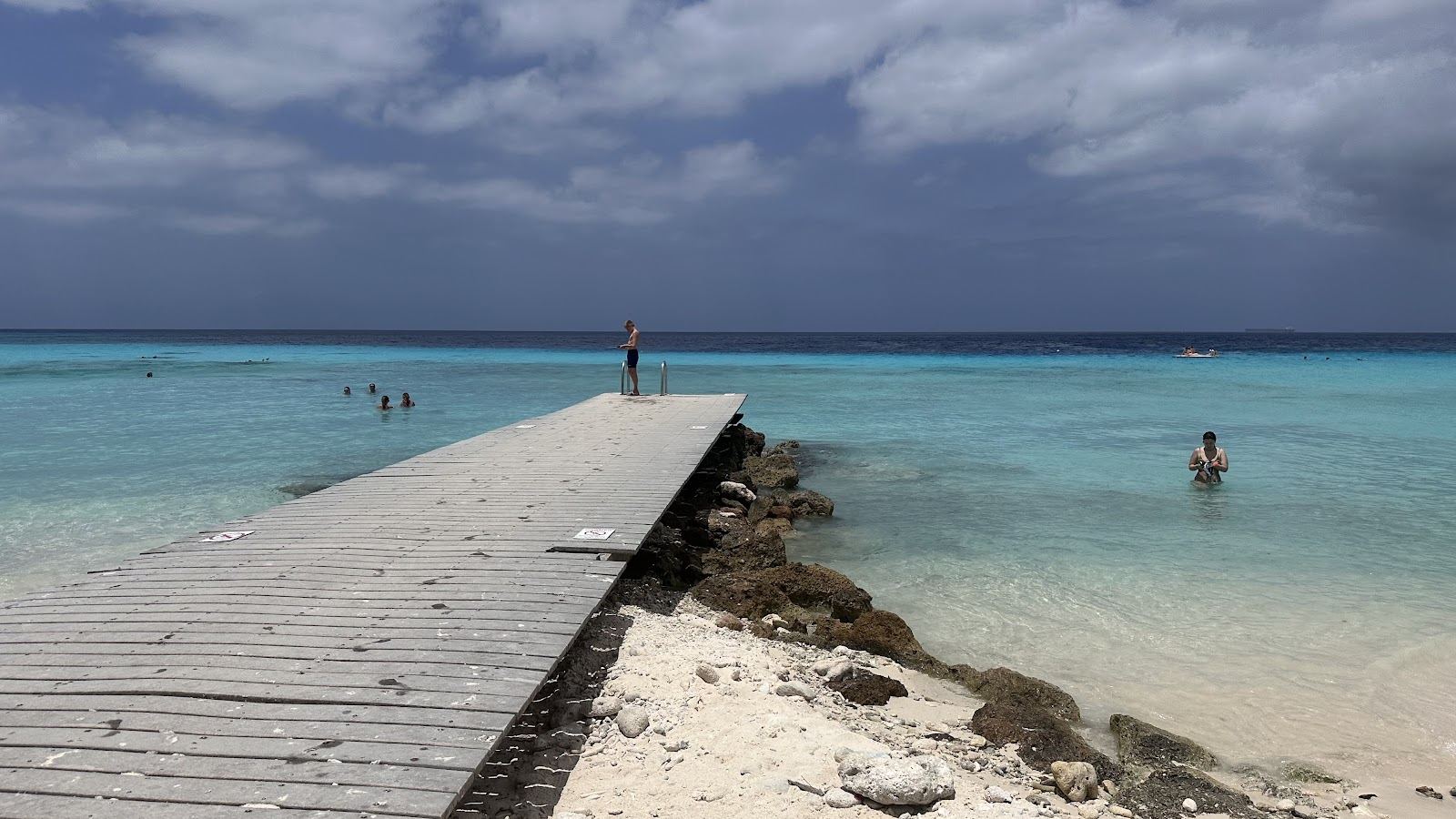 Calm clear turquoise water in a sheltered reef bay with pale sand on the coast of Curacao