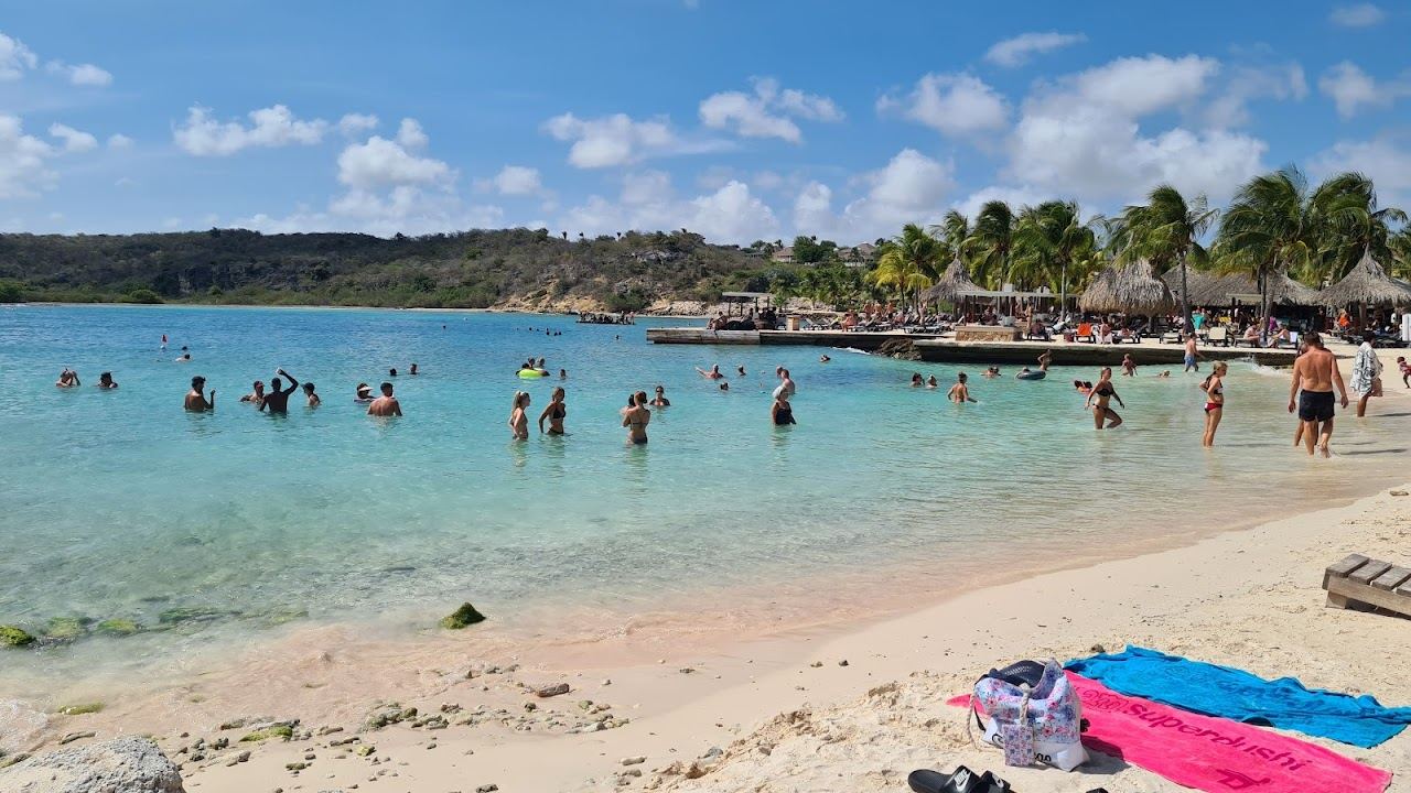 Turquoise sheltered bay, soft sand and beach clubs at Jan Thiel Beach on the southeast coast of Curacao