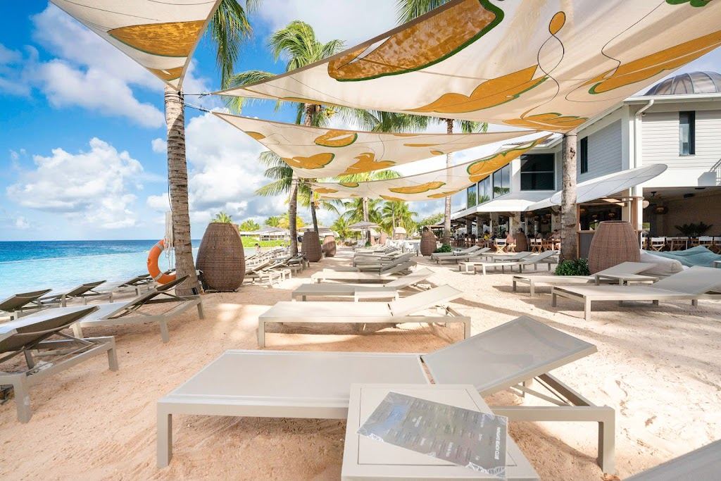Infinity pool blending into the sea with loungers at Papagayo Beach Club on Jan Thiel Beach in Curacao