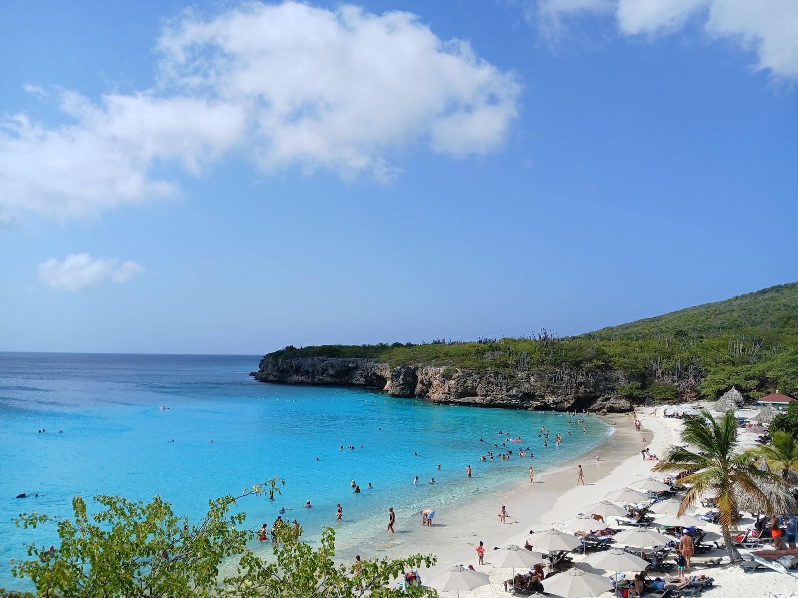 The sun dropping toward the sea off a turquoise cove on the west coast of Curacao