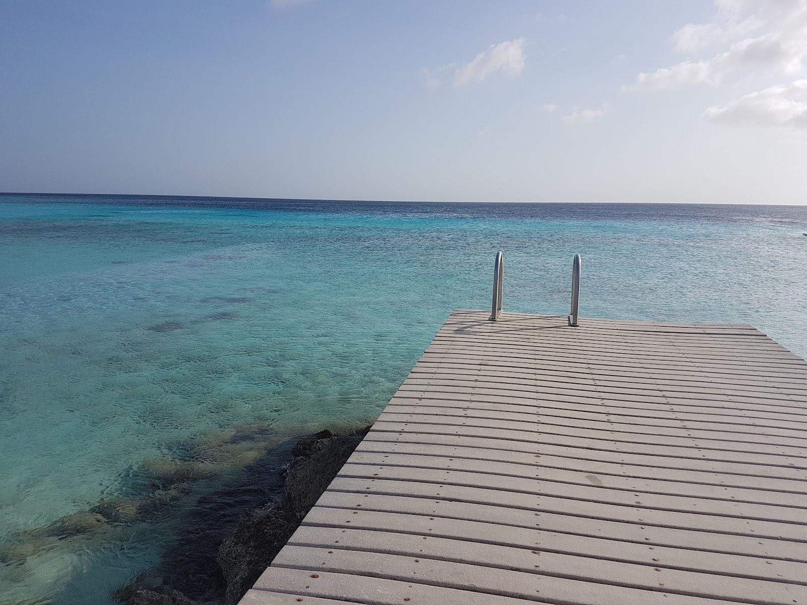 Clear reef water and twin piers at Playa Porto Mari on the west coast of Curacao