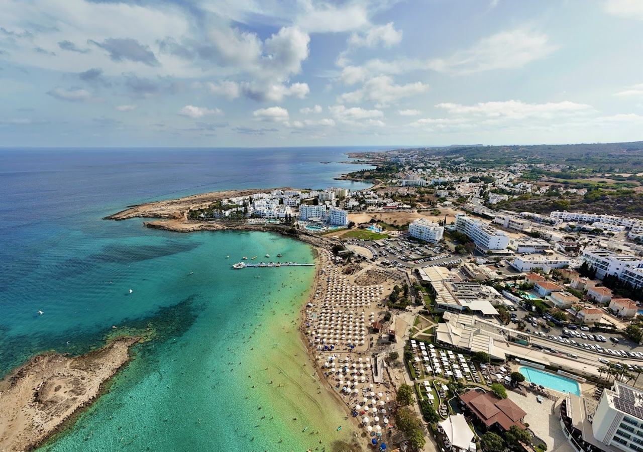 The clear shallow water and curving sand of Fig Tree Bay in Protaras, eastern Cyprus