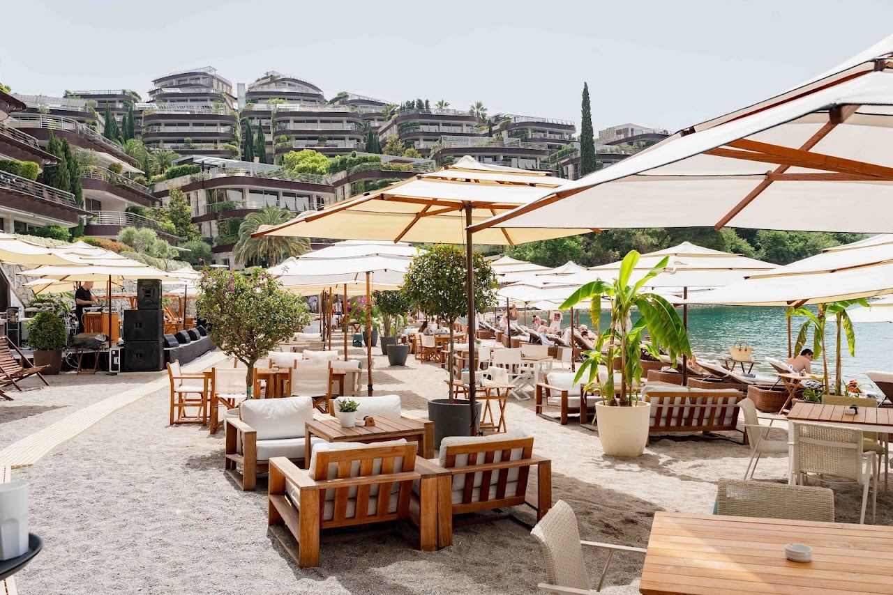 Sunbeds on the sandy resort beach of Dukley Beach and Bar on the Zavala peninsula, Budva