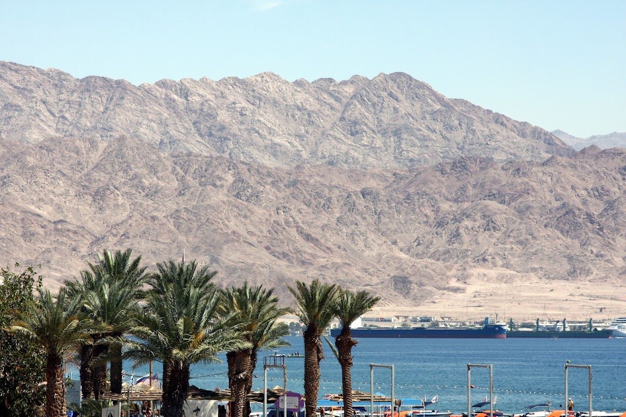 Calm Red Sea water and the desert mountains of Jordan beyond North Beach at Eilat, Israel