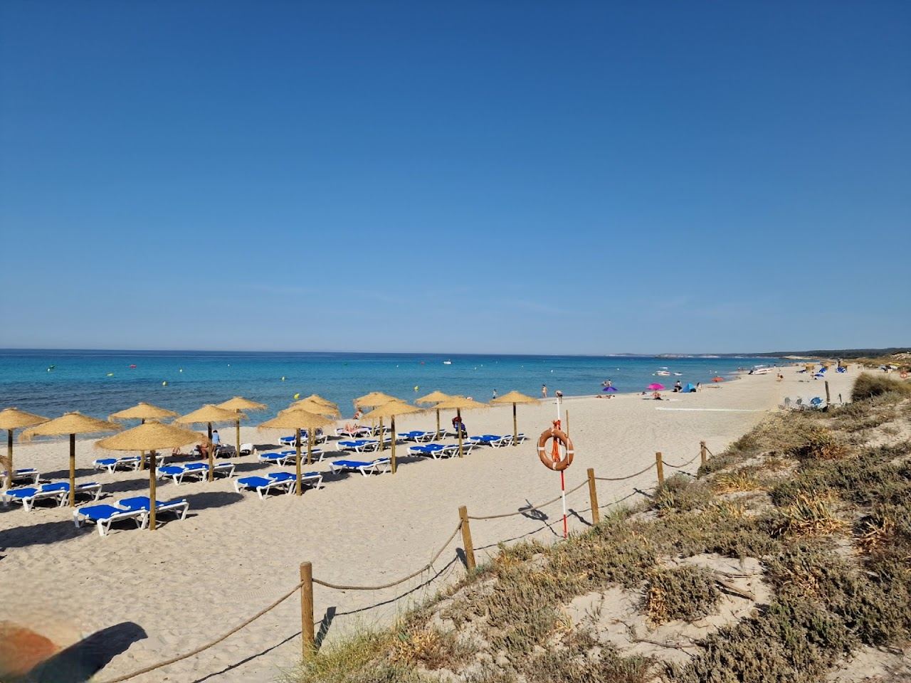 The long pale sand and dunes of Son Bou beach stretching west along the south coast of Menorca