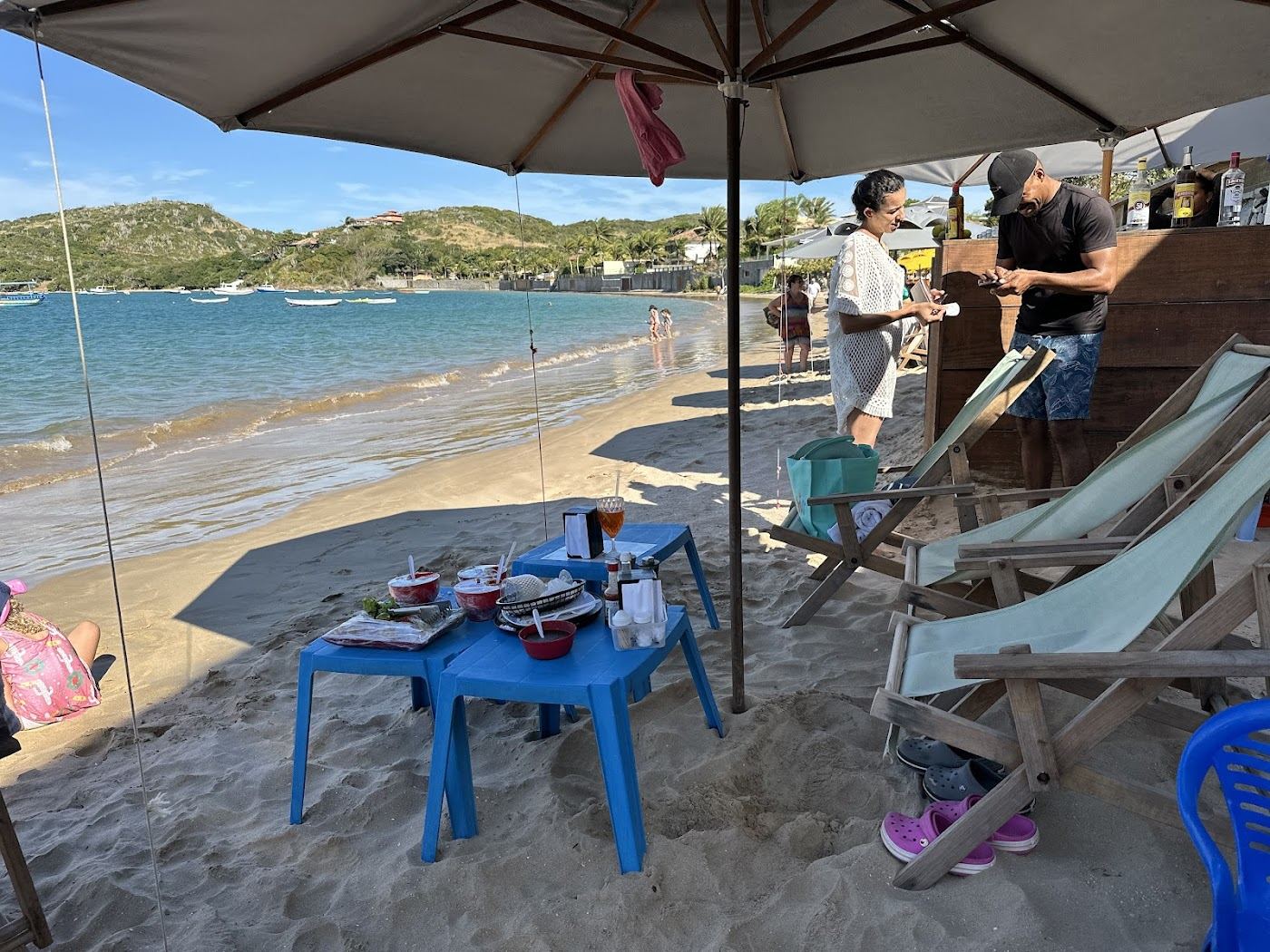 Kayaks and beach kiosks along the calm horseshoe bay of Praia da Ferradura in Buzios