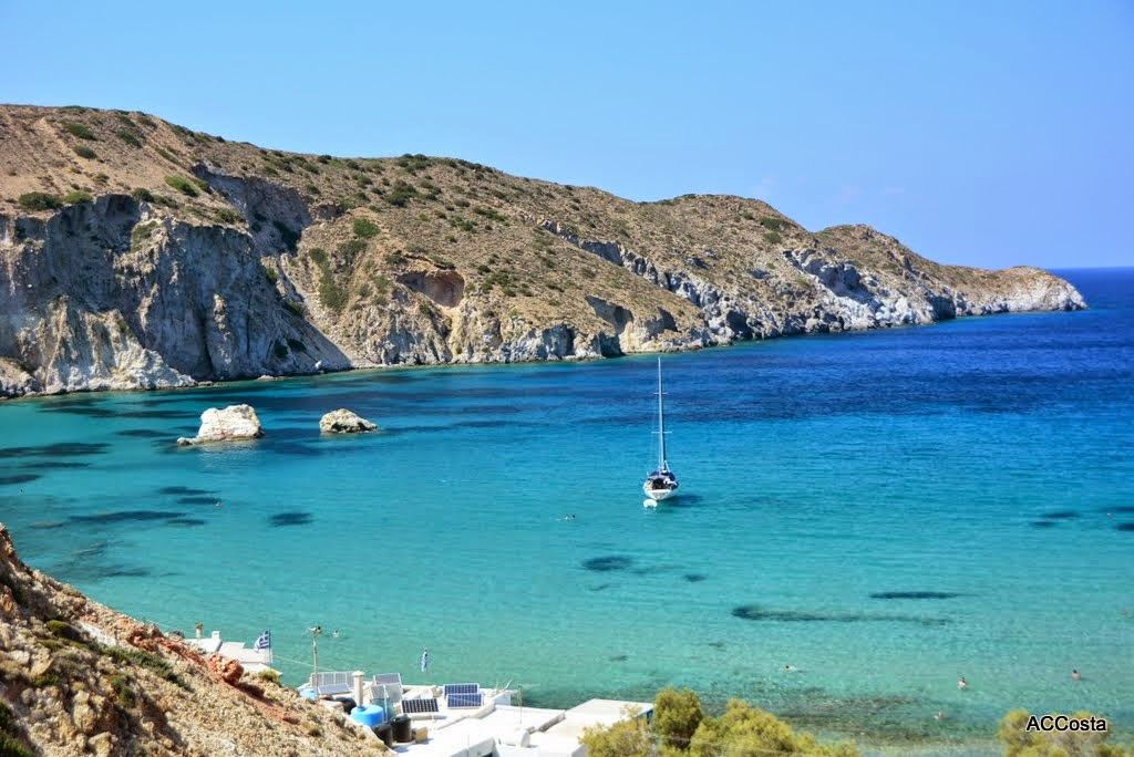 The small sheltered beach of Firopotamos beside white fishing boat houses and a chapel with clear water on the north coast of Milos