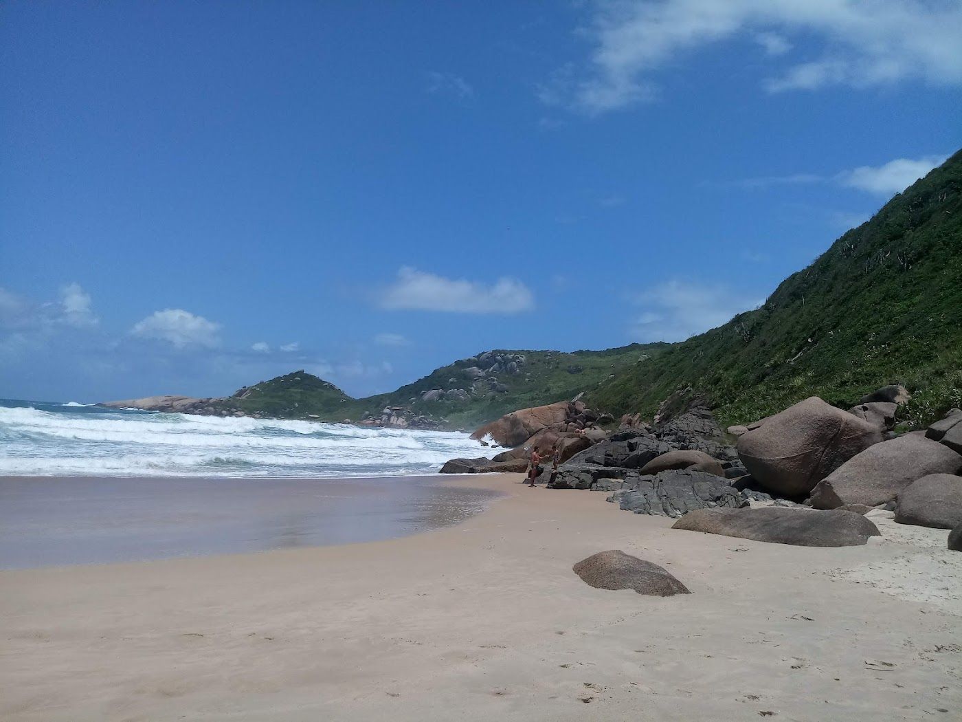 Surf rolling into the golden sand of Praia Mole on Florianopolis island in southern Brazil
