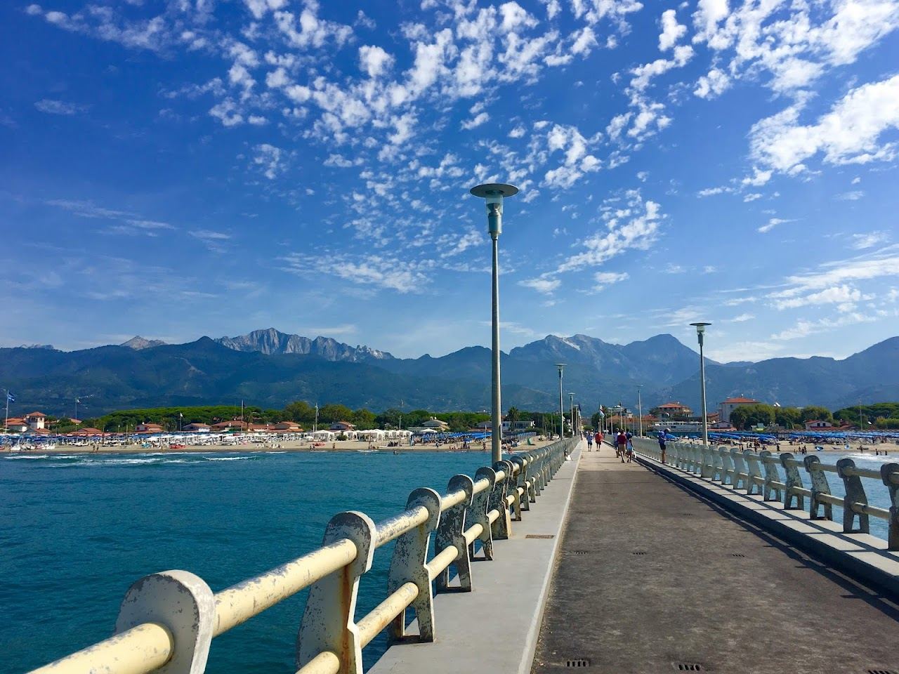 Wide golden beach and pier at Forte dei Marmi with the Apuan Alps behind on the Tuscany coast