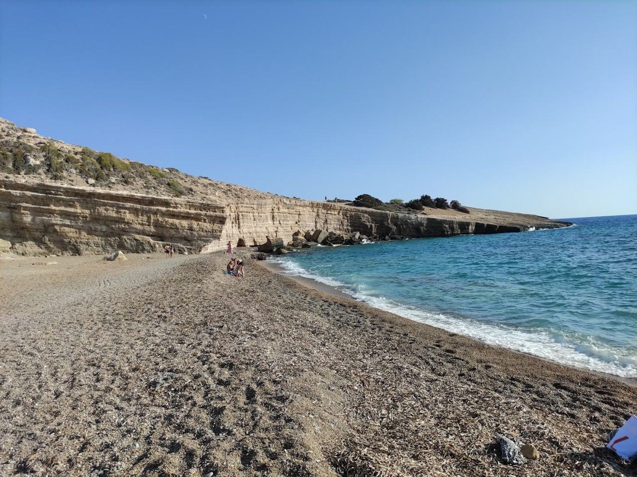 Remote cove of clear water beneath dramatic cliffs and rock formations at Fourni beach near Monolithos on the wild west coast of Rhodes