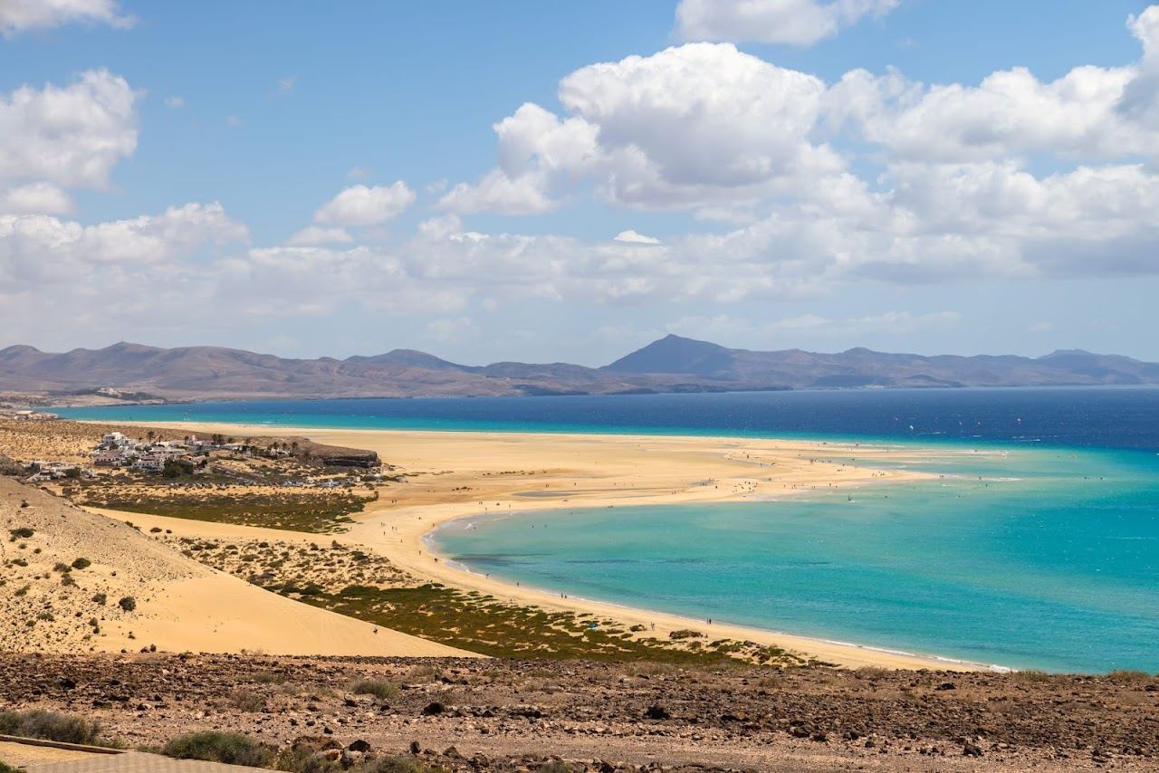 Windsurfers and a wide tidal lagoon on the wind swept sands of Sotavento in Fuerteventura