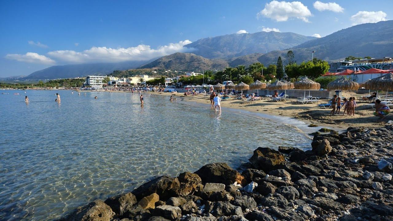 Very long sandy beach and the small chapel on the rocks at Georgioupoli on the north coast of Crete