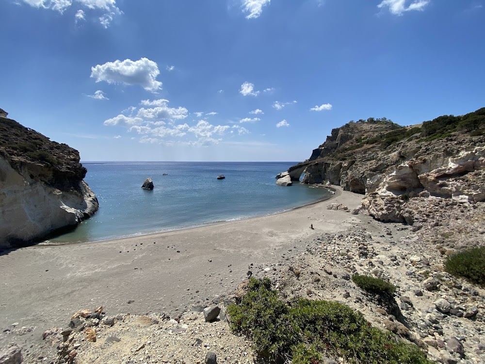 The pale cliffs and clear water of Gerontas beach with its natural sea arch on the wild south coast of Milos