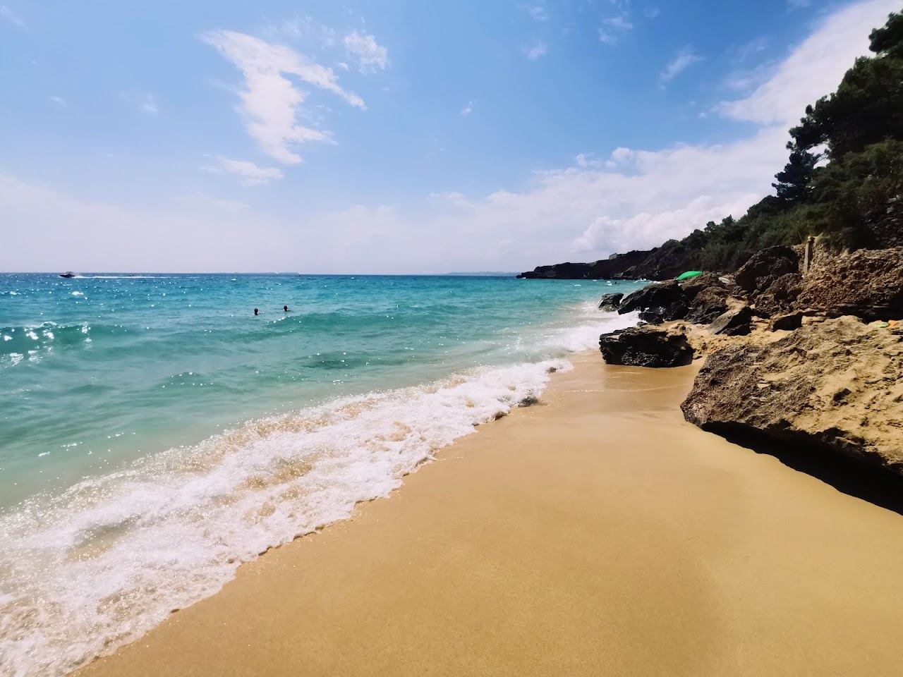 The wider Lassi coastline of grey gold sand and clear water on the west coast of Kefalonia