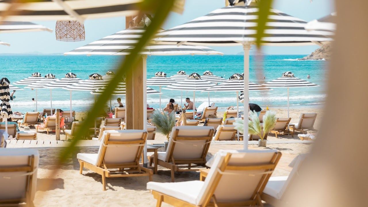 A relaxed beach lounge with sunbeds and a calm shallow bay at Naxaki on Naxos