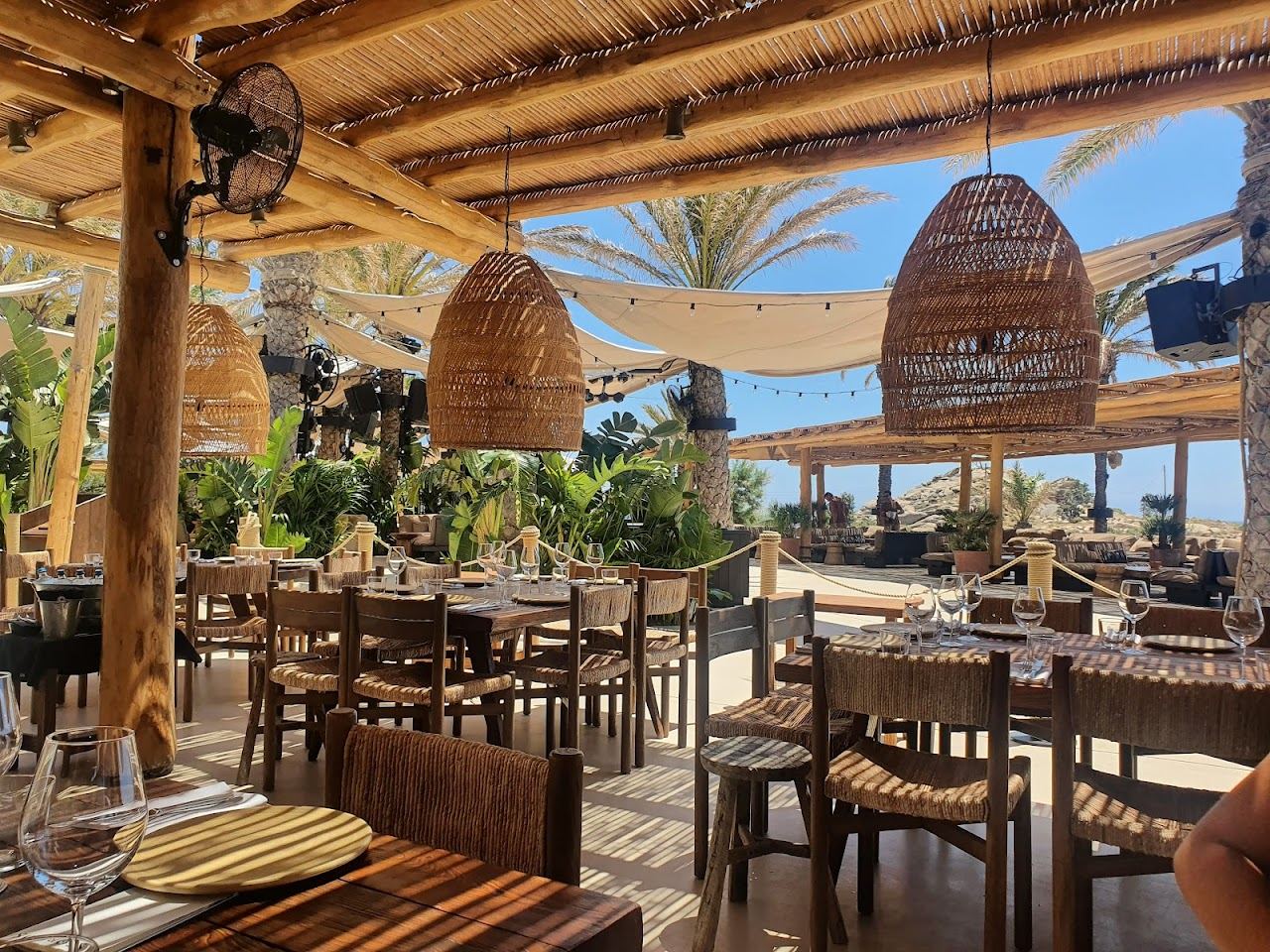 A bohemian wooden beach club with daybeds above the sand at Scorpios on Paraga beach Mykonos