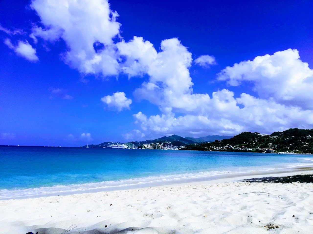 A lively stretch of Grand Anse sand at golden hour in Grenada