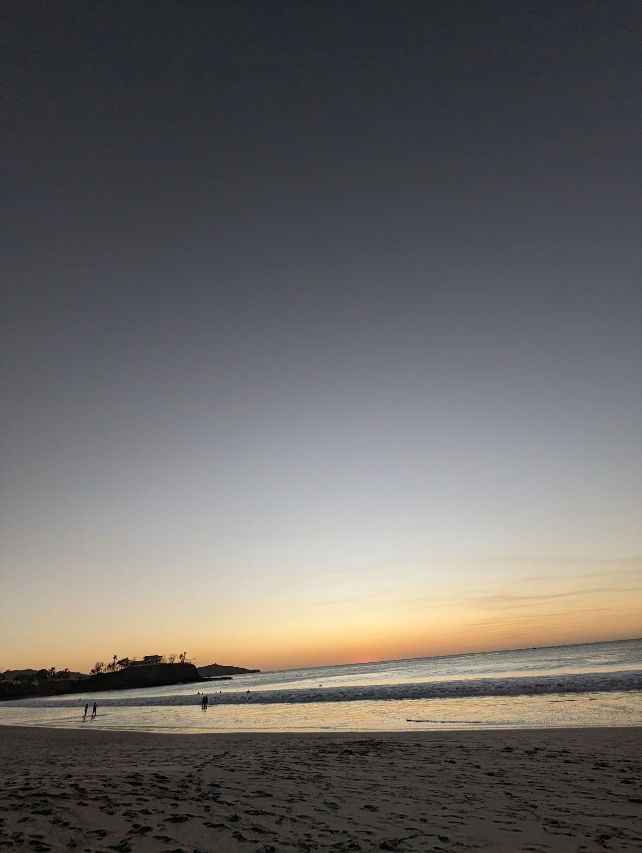 Golden sunset light over a quiet Guanacaste beach and headland