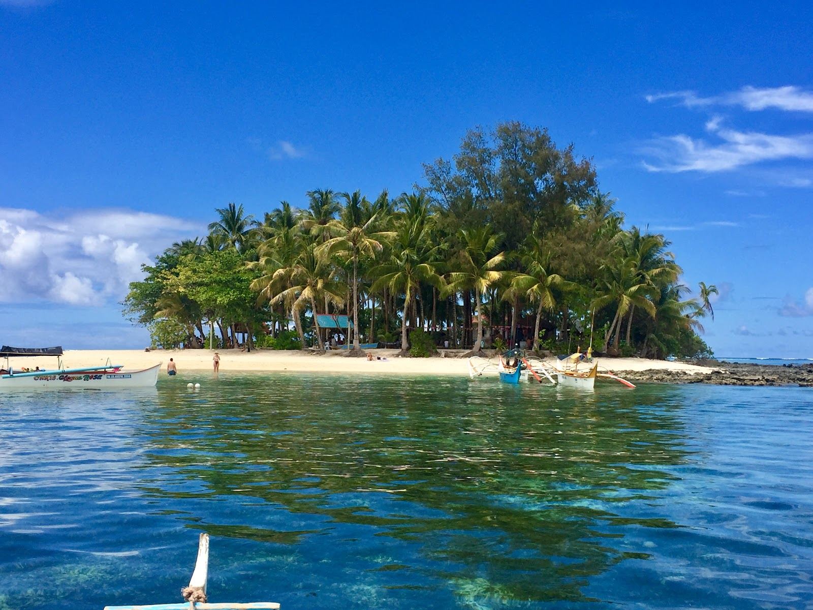 The tiny palm crowned islet of Guyam ringed by clear turquoise off General Luna in Siargao