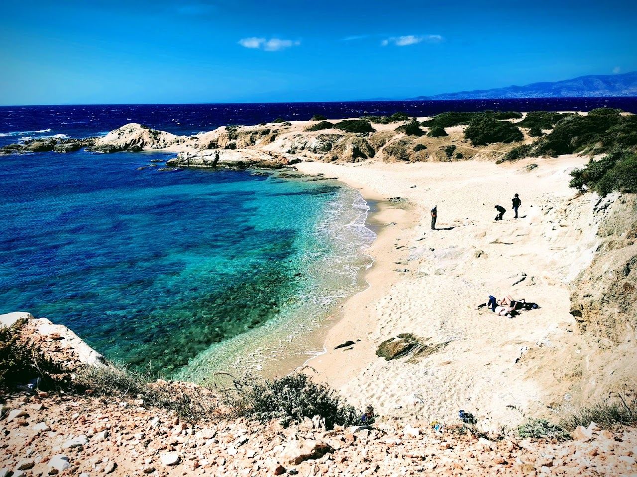 The clear turquoise water and pale sand of the small Hawaii cove near Alyko in Naxos