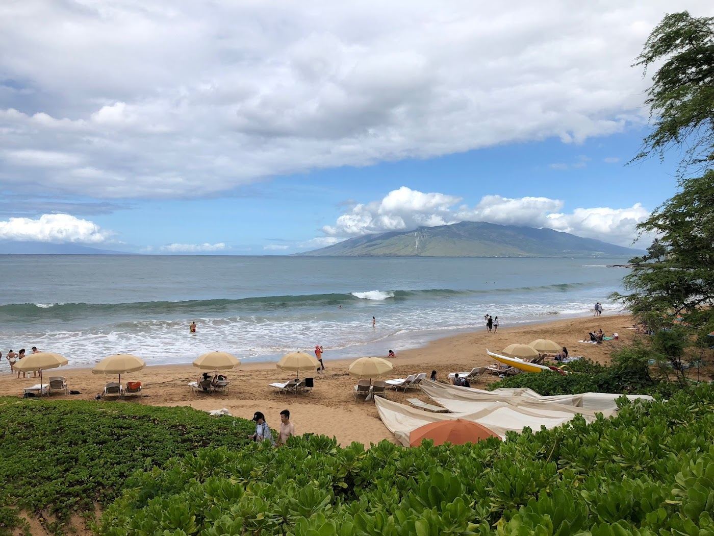 The clean arc of Wailea Beach in front of the resorts with a paved coastal path on Maui