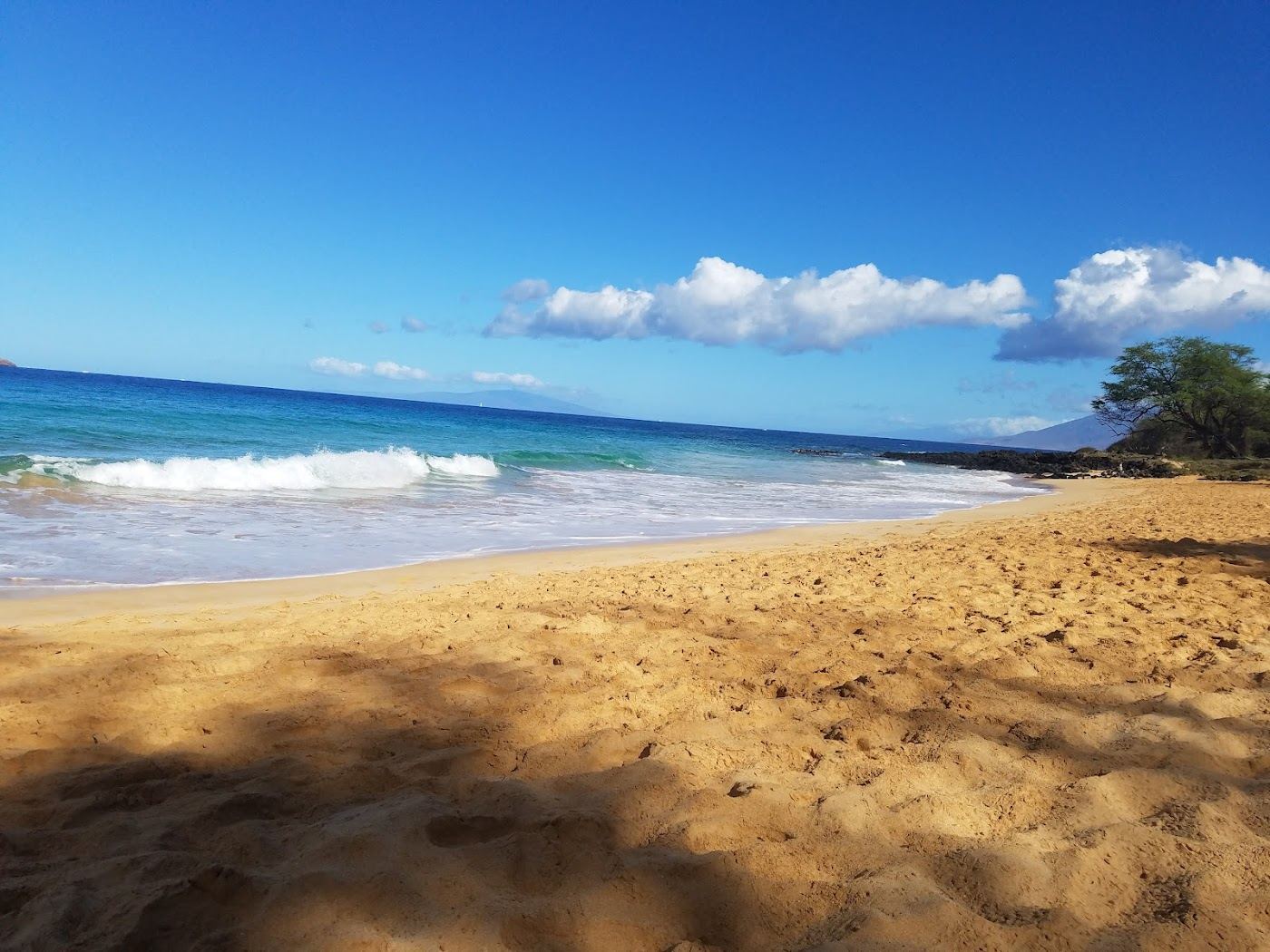 The sheltered cove of Little Beach reached over the rocks behind Big Beach at Makena on Maui