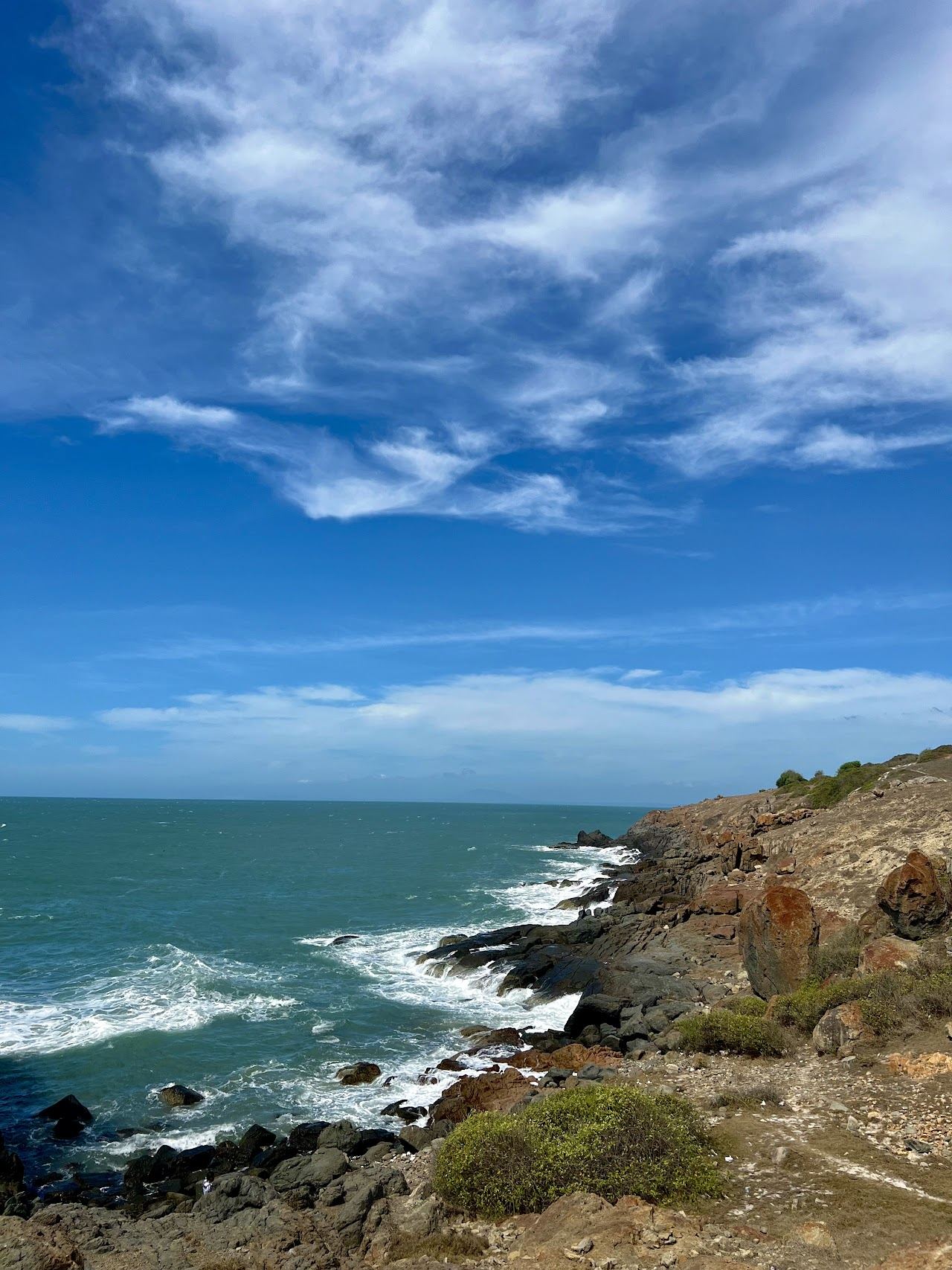 The rocky shore and clear water of Hon Ghenh islet off the Mui Ne coast