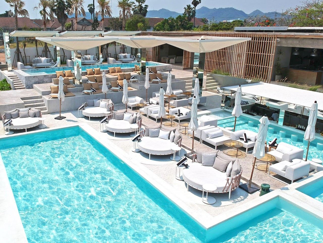 Daybeds and a pool deck at a beachfront day club on the Hua Hin shore