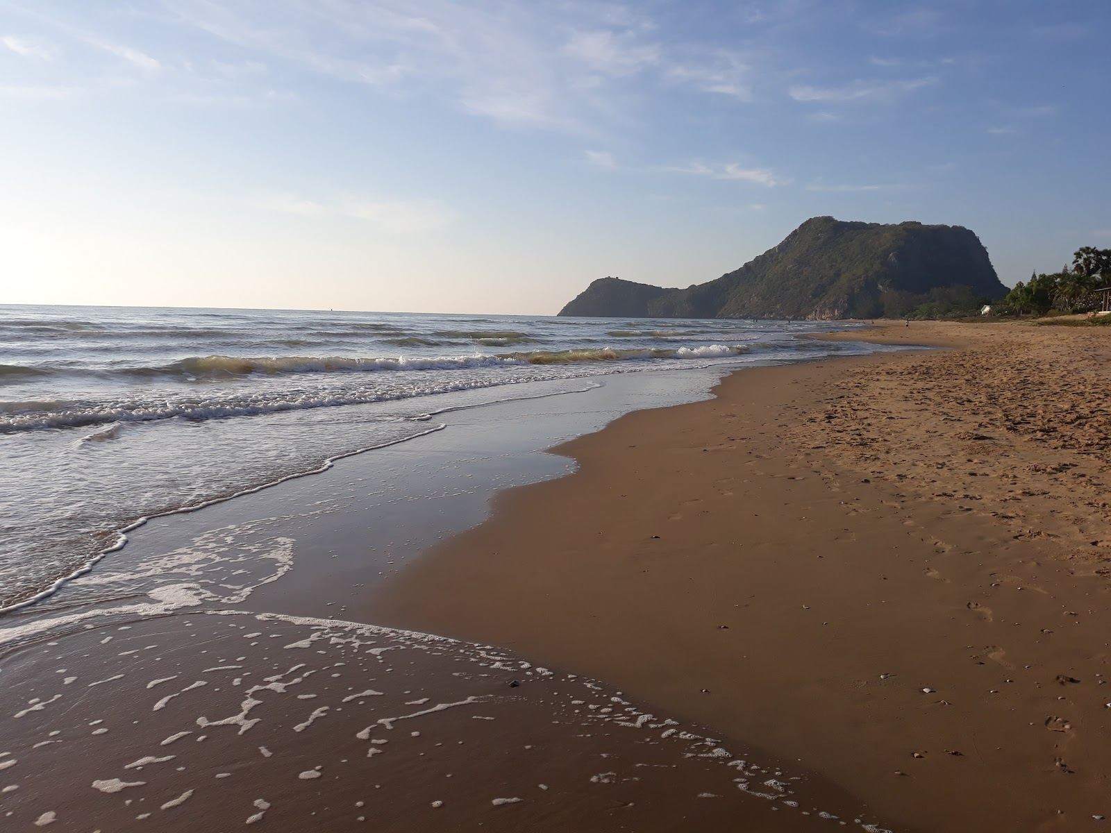 A quiet palm backed beach with calm gulf water south of Hua Hin at soft morning light
