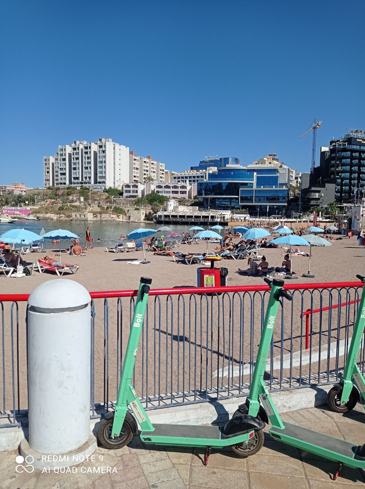 The small sandy inlet and waterfront of St George's Bay in St Julian's, Malta, below the rooftop clubs