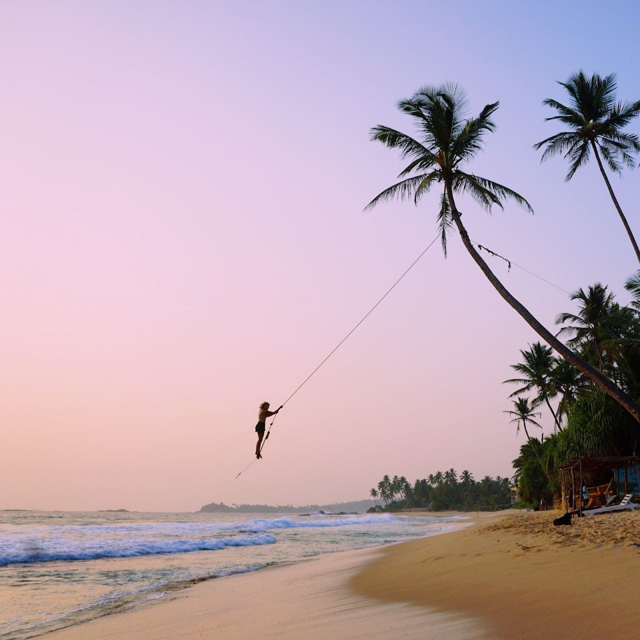 The reef protected turquoise bay and palm rope swing at Dalawella near Unawatuna in Sri Lanka