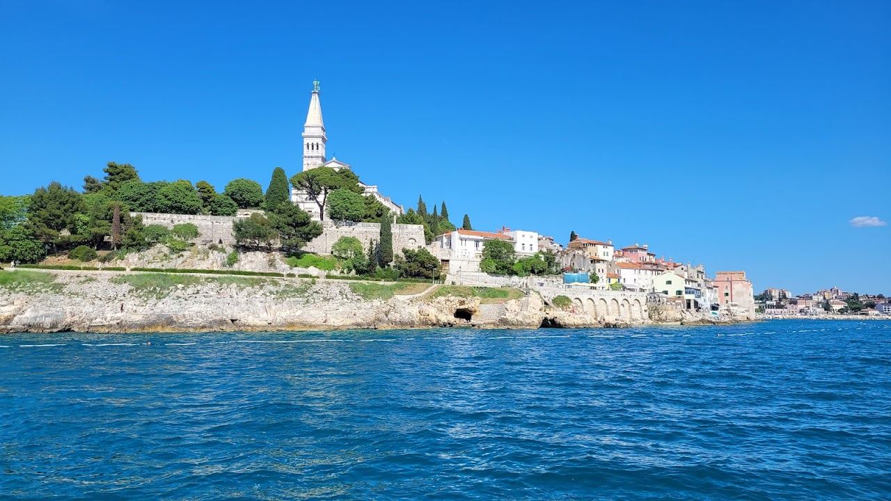 The sun setting over the Adriatic behind Rovinj old town and its campanile on the west coast of Istria