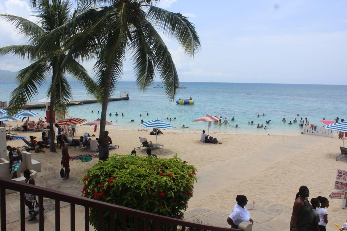 Clear calm water and pale sand at Doctors Cave Beach in Montego Bay Jamaica on a bright day