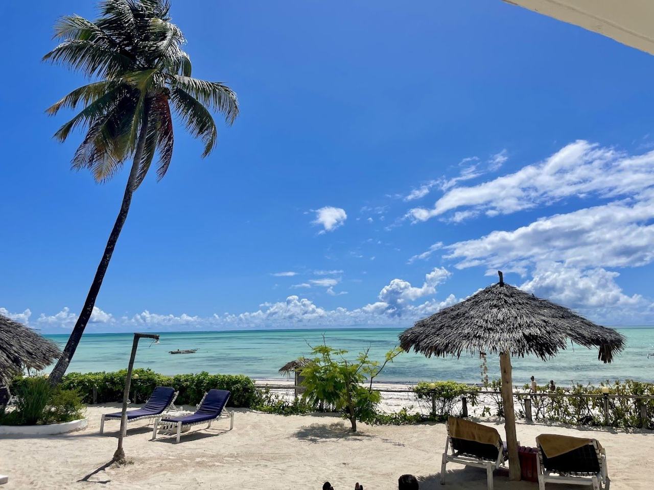 Turquoise lagoon, pale sand and a traditional fishing village along the shore at Jambiani on the south east coast of Zanzibar