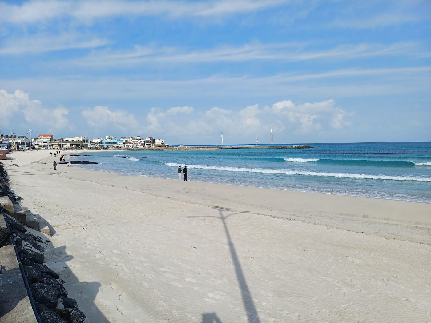 Warm evening light over turquoise water and pale sand on the Jeju coast