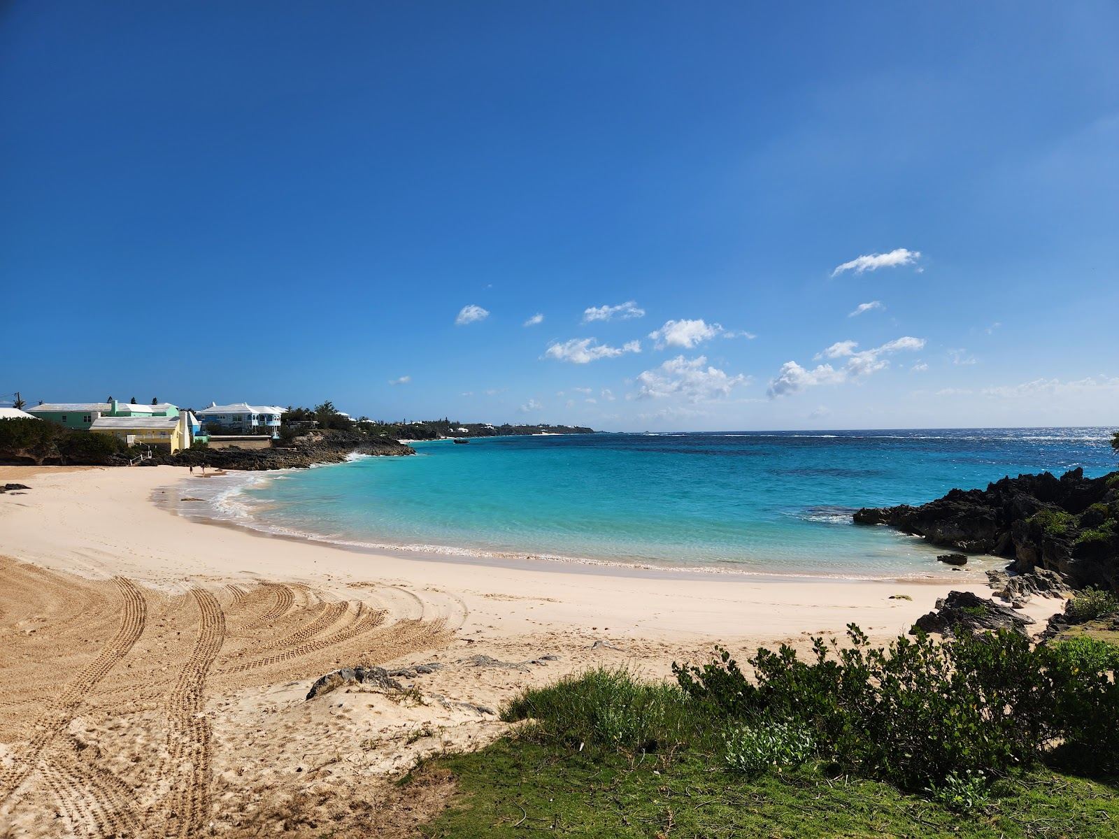 Pink sand, rocky headland and clear shallow water at John Smiths Bay in Bermuda
