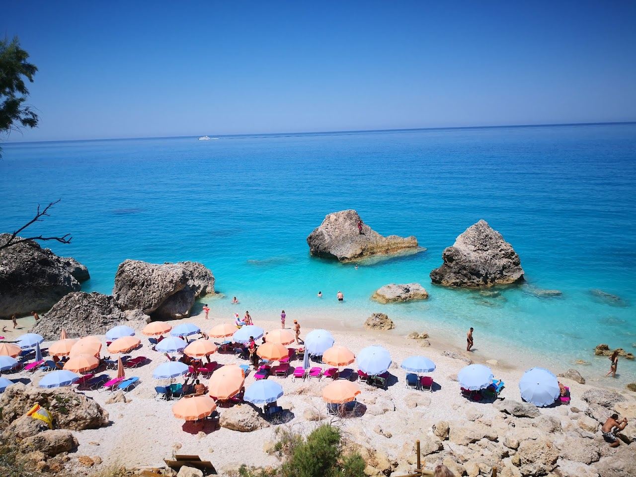 White gravel and turquoise water with large seaside rocks at Kalamitsi beach, also called Kavalikefta, on the west coast of Lefkada