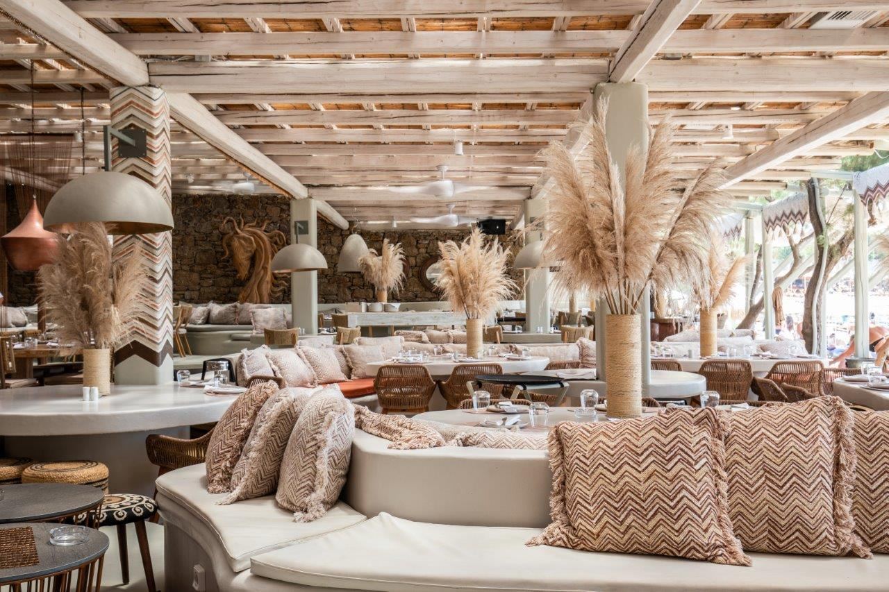 Sunbeds and parasols on the sand at Kalua on the sheltered Paraga cove in Mykonos