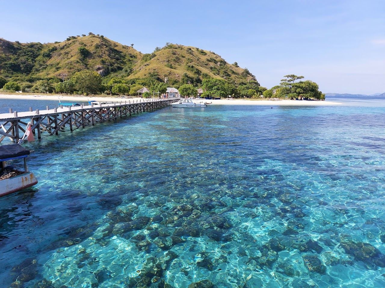 White sand and a jetty over clear shallow water at Kanawa Island