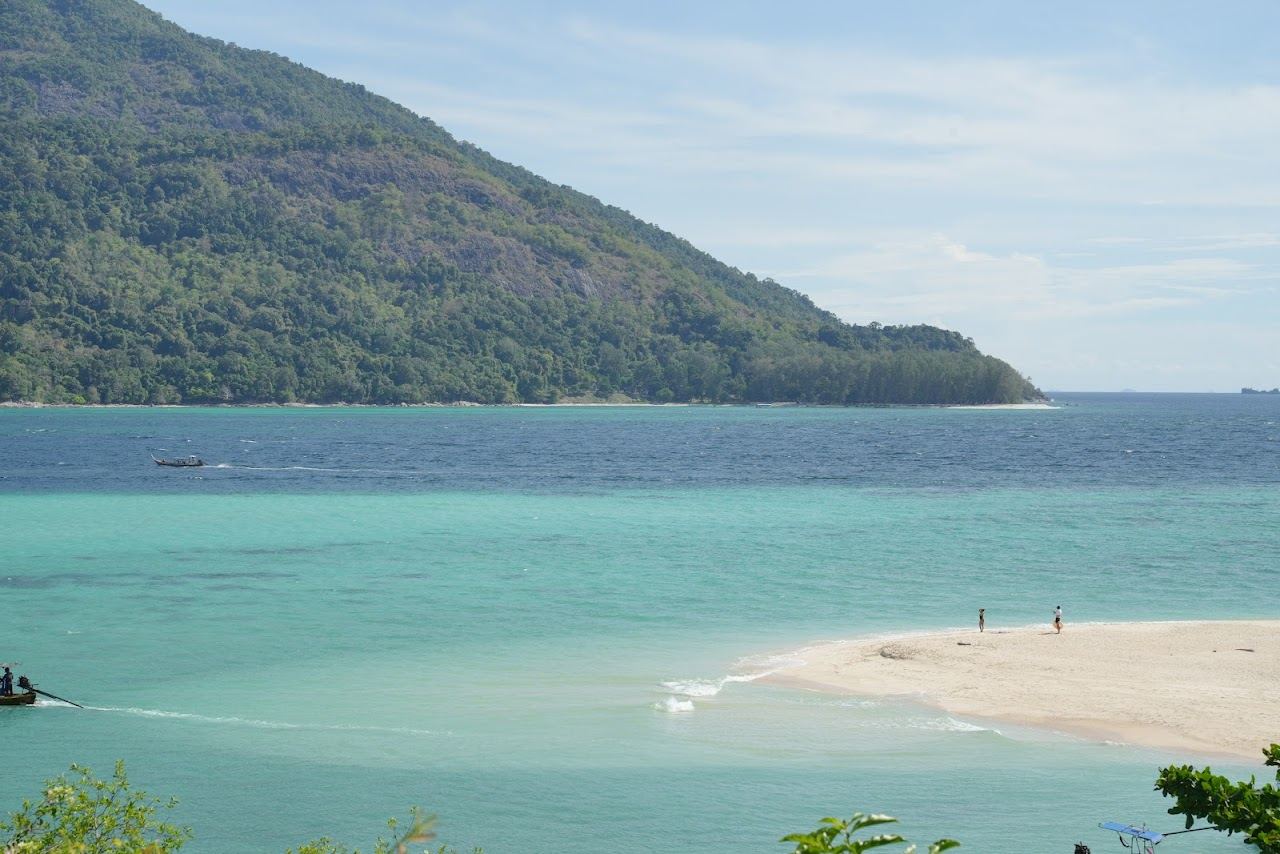 The pale sandbar and turquoise shallows of Karma Beach at the north tip of Koh Lipe facing Koh Adang